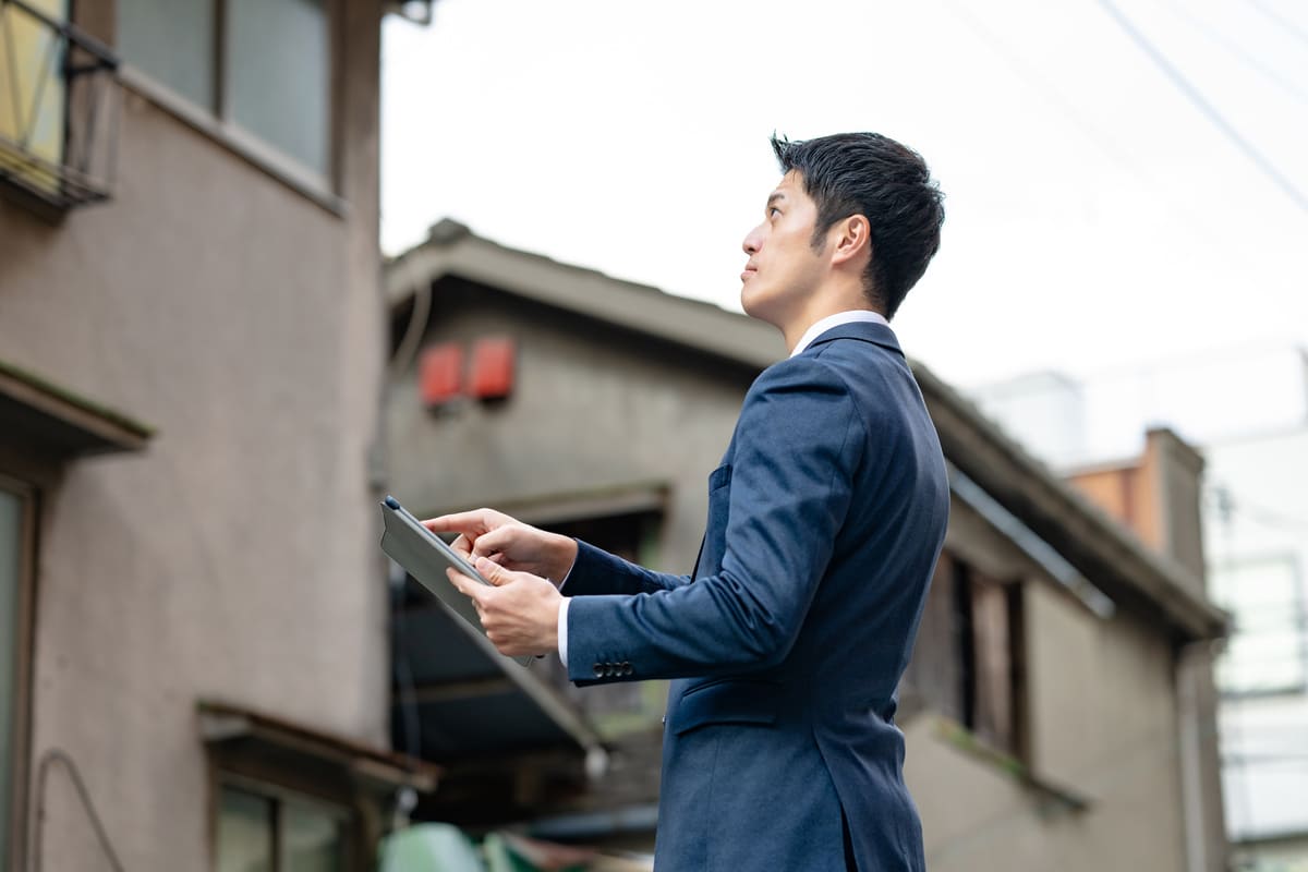 古い家と不動産会社の男性