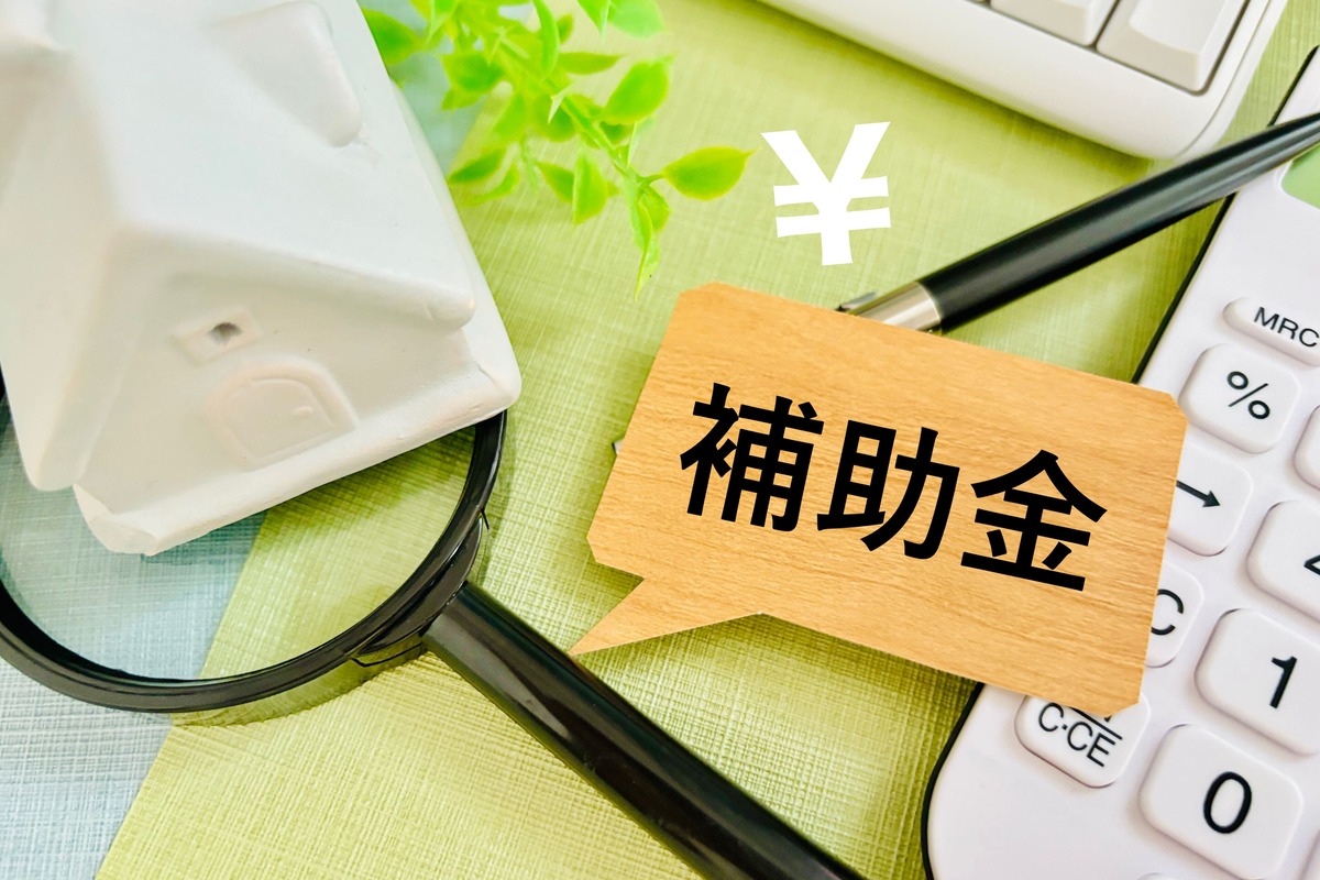 補助金のブロックと家、虫眼鏡